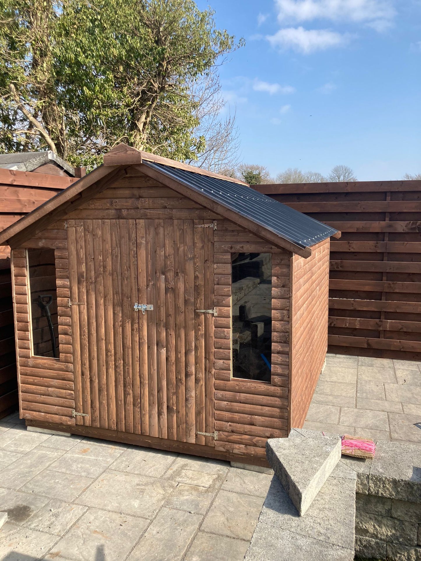 Log Cabin with Double Doors and 2 long windows and tin roof.